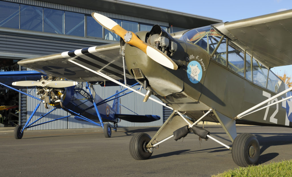 Two military aircrafts outside of the Espace Air Passion museum: a Piper L4H and a Morane Saulnier MS-505 Criquet